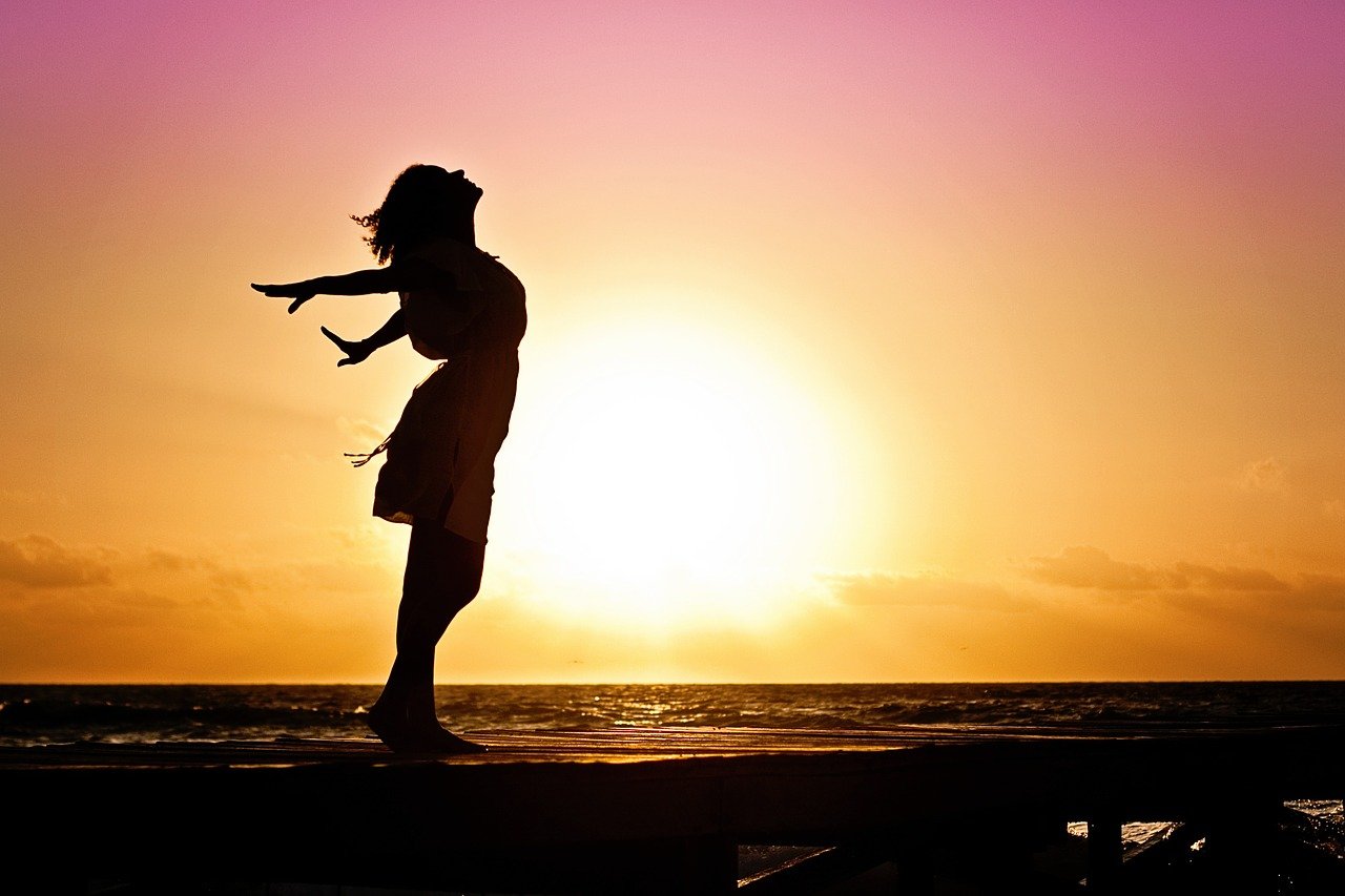 Frau glücklich Sonnenuntergang Selbstliebe lernen Tipps Tricks